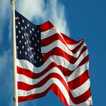 American flag waving in sunlight representing freedom, faith, Constitution, and American values of justice and accountability